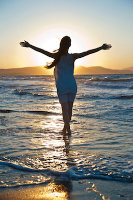Woman Walking on the Beach Enjoying the Benefits of Energy Balancing Therapy